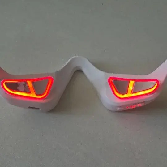 Photo client : lunettes anti-cernes allumées, lumière rouge visible sous les yeux